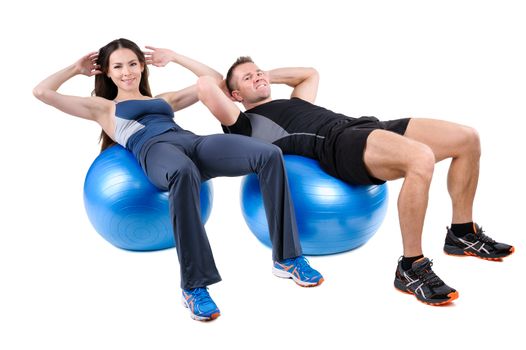 Young couple shows starting position of Abdominal Fitball Workout, isolated on white