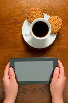 close-up of female hands with tablet and coffee cup