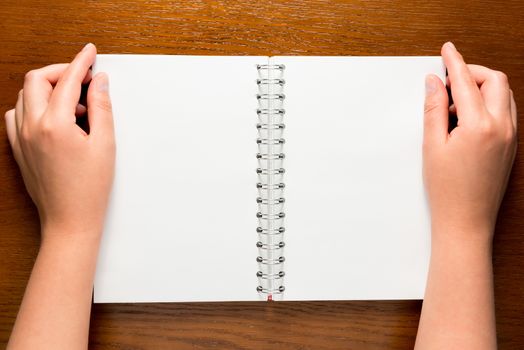 notepad with clean sheets and a top view of female hands