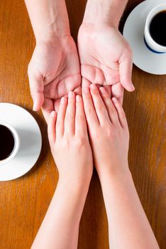 male and female hands on the table with cups of coffee