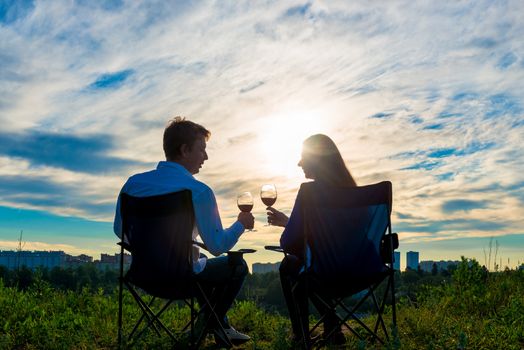 young married couple with a glass of wine at sunset