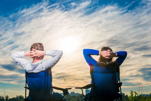 lovers sit on the chairs and look at the beautiful morning sky