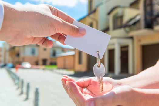 key of apartment and a card for an inscription in the hands of people