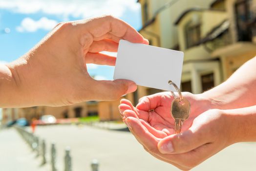 the seller transfers key to the apartment in the women's hands. space on the card for an inscription