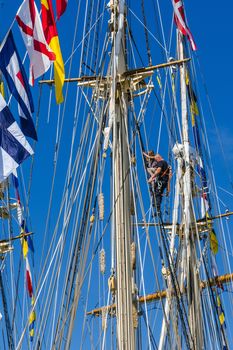 Girl secured by a seaman climbs up the mast during a boat tour in the time of Nordic Cadet Meeting (NOCA) in Ystad – annual event arranged by Nordic naval warfare academies.