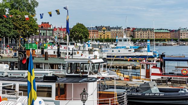 Boats moored at the Skeppsholmen islet and view on Strandvagen, a boulevard completed for the Stockholm World's Fair in 1897, the most prestigious avenue in town.