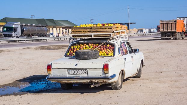 Old type car fully loaded with apples by the highway in Zarat, on September 13, 2012. Individual economic activity is still very important in rapidly developing Azerbaijan.