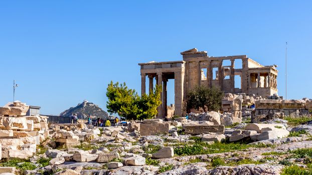 Tourists take photos of the Old Temple of Athena on the Acropolis of Athens, an ancient citadel on a hill above Athens, home to several relics, a UNESCO World Heritage Site.