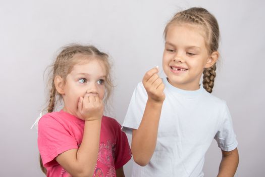 Six year old girl showing her the other girl had fallen Milk front upper teeth