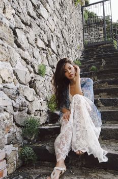 A girl in bohemian style on the rocky step