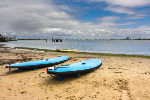 Three surfboards resting on a quiet beach in St Kilda, Melbourne.