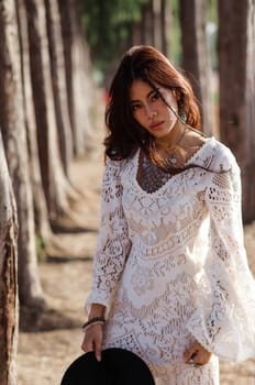 A lady in white bohemian dress in the wood