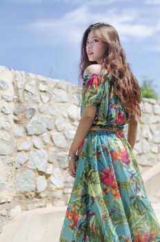 Bohemian girl posing in front of white wall