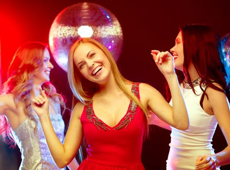 new year celebration, friends, bachelorette party, birthday concept - three beautiful woman in evening dresses dancing in the club