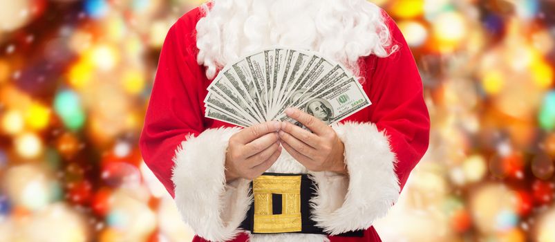 christmas, holidays, winning, currency and people concept - close up of santa claus with dollar money over red lights background