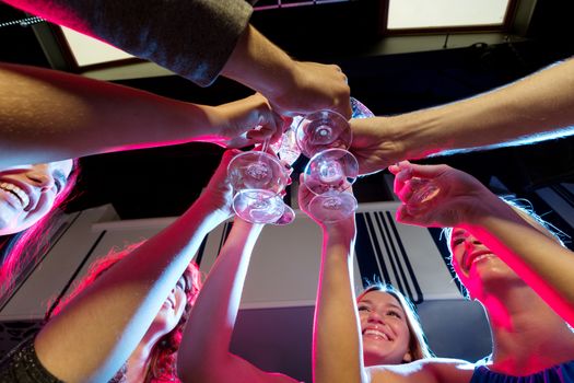 party, holidays, celebration, nightlife and people concept - smiling friends with glasses of champagne in club