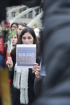 CANADA, Toronto: A woman holds roses and a sign reading La France n'a pas peur (France not afraid) as hundreds gather at Nathan Phillips Square in Toronto on November 14, 2015, a day after a series of terror attacks in Paris. Islamic State has claimed responsibility for the attacks, which killed at least 129 people and left hundreds more injured in scenes of carnage at a concert hall, restaurants and the national stadium on Friday, November 13.