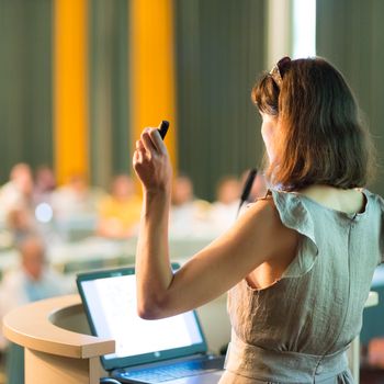 Female speaker at Business Conference and Presentation. Audience at the conference hall. Business and Entrepreneurship. Business woman. Horizontal composition.