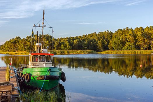 Landscape with a boat moored at the wooden pier near Kalmar, Sweden.