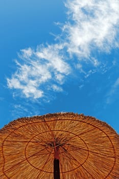 Reed sun umbrella on a beach.