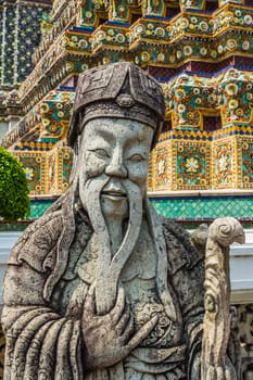 Ancient statue in the complex of Wat Pho, the Temple of the Reclining Buddha in Bangkok, Thailand.