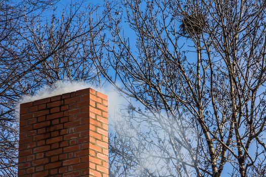 Chimney of brick against the blue sky.