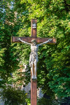 Statue of Jesus Christ crucified. In the very background the Church of the Immaculate Conception of the Blessed Virgin Mary in Katowice, Silesia region, Poland.