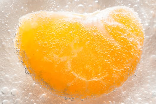 The photo depicts a tangerine in bubbles