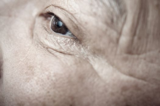 Close-up view on the eye of elderly human