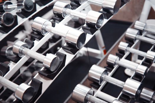 Group of barbells arranged in row at the gym. Horizontal photo