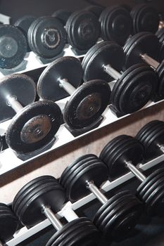 Group of barbells arranged in row at the gym. Vertical photo