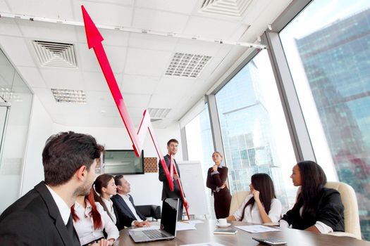 Business people discuss red arrow of income growth at meeting