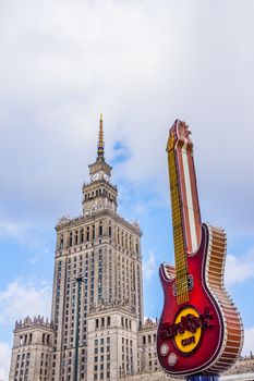 Palace of Culture and Science, built in a socialist realism style city landmark, preceded by the guitar, famous symbol of Hard Rock Café situated nearby.