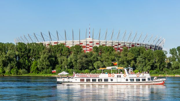 Polish National Stadium in Warsaw preceded by the pleasure boat on the Vistula river.  Designed and built for UEFA EURO 2012 tournament co-hosted by Poland and Ukraine.
