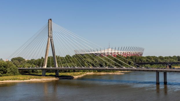 The National Stadium preceded by The Swietokrzyski bridge over Vistula river in Warsaw. Designed and constructed for UEFA EURO 2012 tournament co-hosted by Poland and Ukraine.