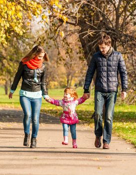 Happy young family walks in the park