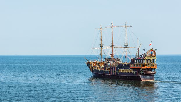 Pleasure boat, designed in old pirate frigate style, by the pier in Sopot. Pleasure cruises are one of the most popular summer attractions in the resort.