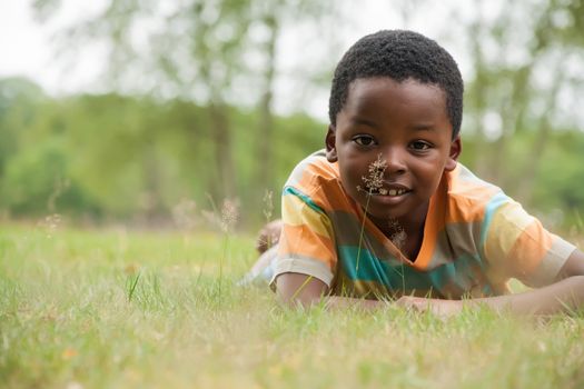 African boy is relacing in the grass