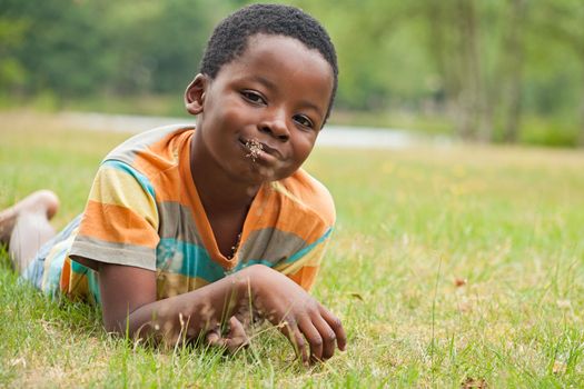 African boy is relacing in the grass