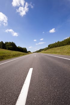   the small rural asphalted road photographed in summertime of year. Belarus