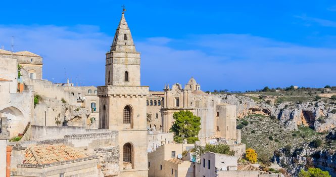 panoramic view of typical stones (Sassi di Matera) and church of Matera UNESCO European Capital of Culture 2019 under blue sky. Basilicata, Italy