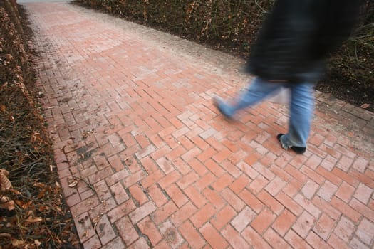 People passing by a brick wall