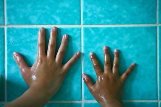 In the bathroom, a child holding a shower head