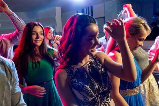 party, holidays, celebration, nightlife and people concept - smiling friends dancing in club