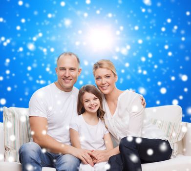 family, childhood, christmas holidays and people concept - smiling mother, father and little girl over blue snowy background