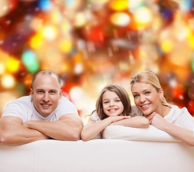 family, childhood, holidays and people - smiling mother, father and little girl over red lights background