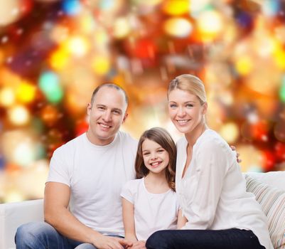 family, childhood, holidays and people - smiling mother, father and little girl over red lights background