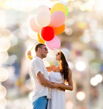 love, wedding, summer, dating and people concept - smiling couple wearing sunglasses with balloons hugging over lights background