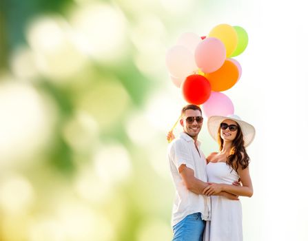 love, wedding, summer, dating and people concept - smiling couple wearing sunglasses with balloons hugging over green background