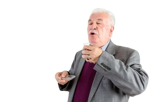 Senior distinguished white haired man enjoying a cup of Turkish tea savoring the flavor and aroma, isolated on white